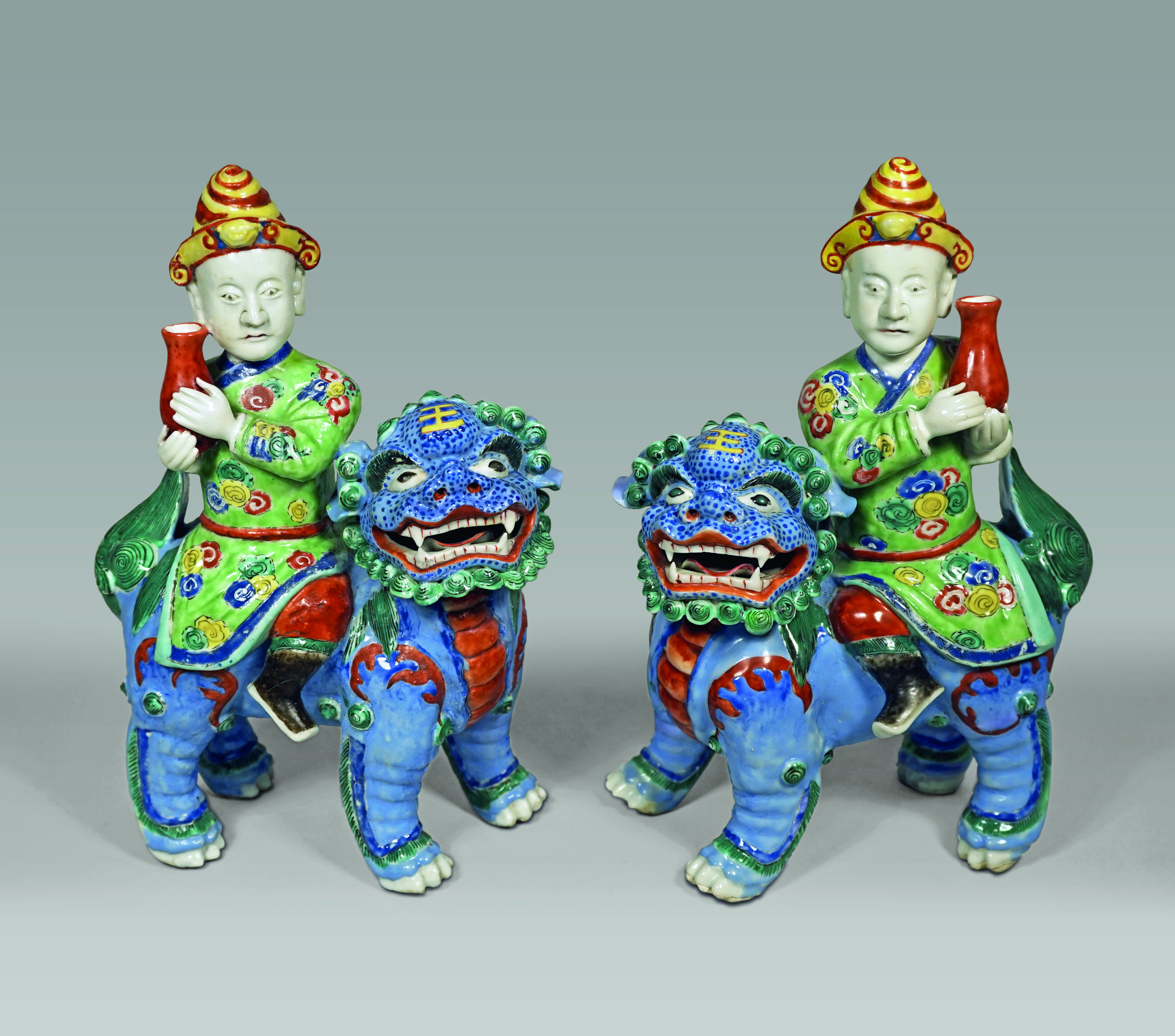 Pair of Chinese Porcelain Figures of Foreigners Riding upon Fu Lions