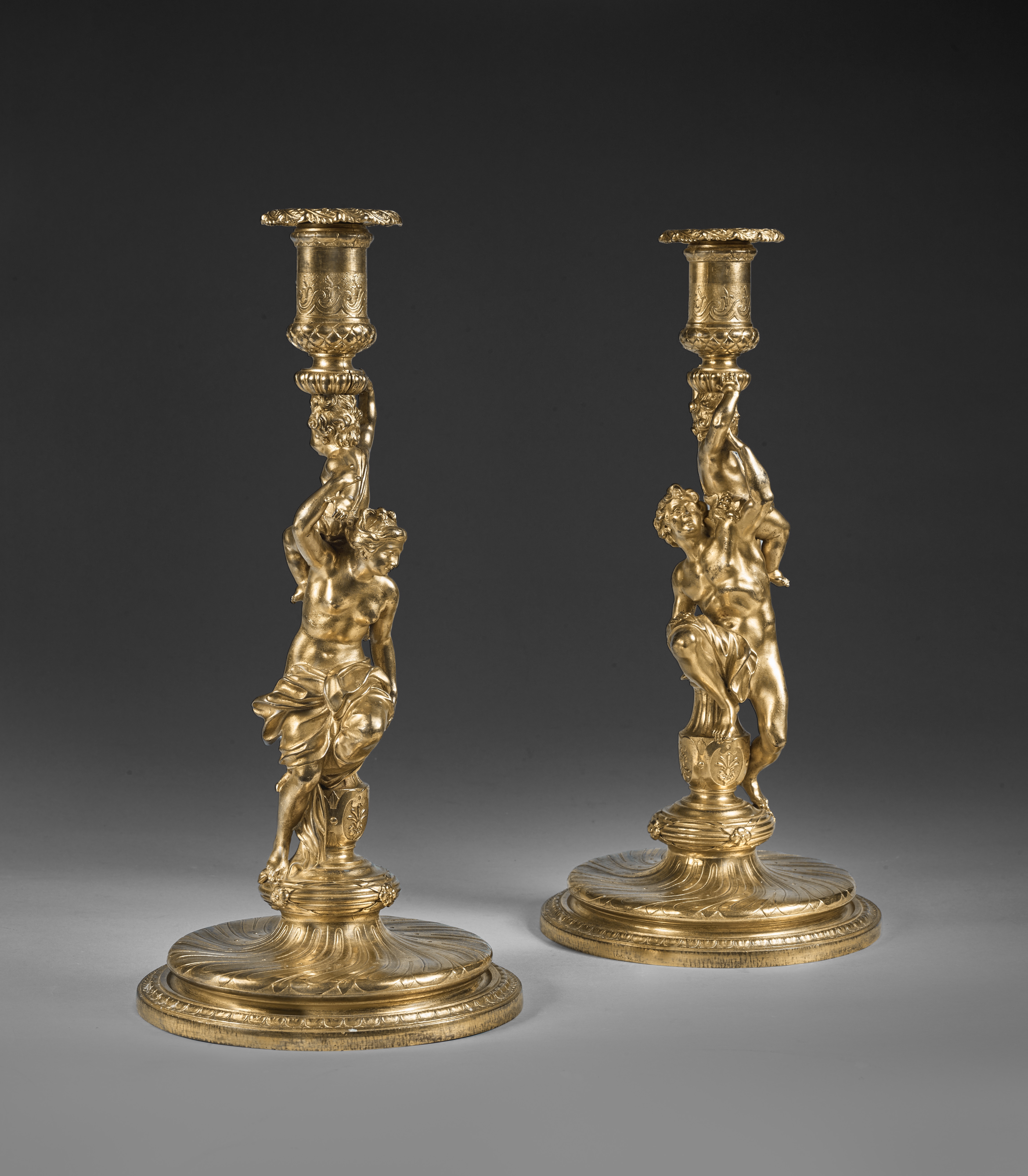 PAIR OF CANDLESTICKS WITH A MAN AND A WOMAN HOLDING A CHERUB